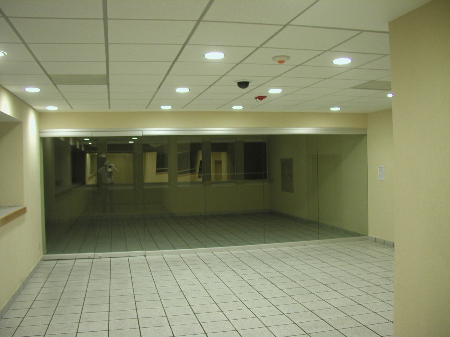 Vestíbulo comercial con plafón reticular y cancelería de cristal